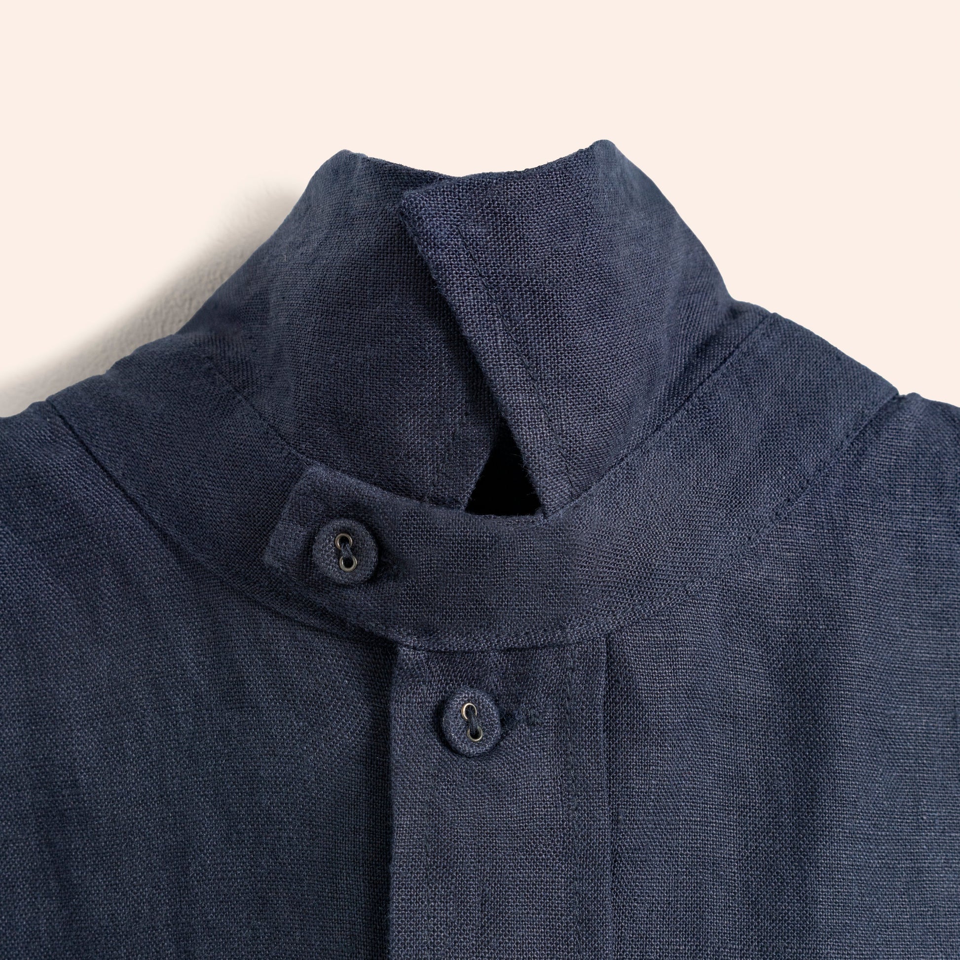 Close-up of a dark blue shirt with buttons on a light background