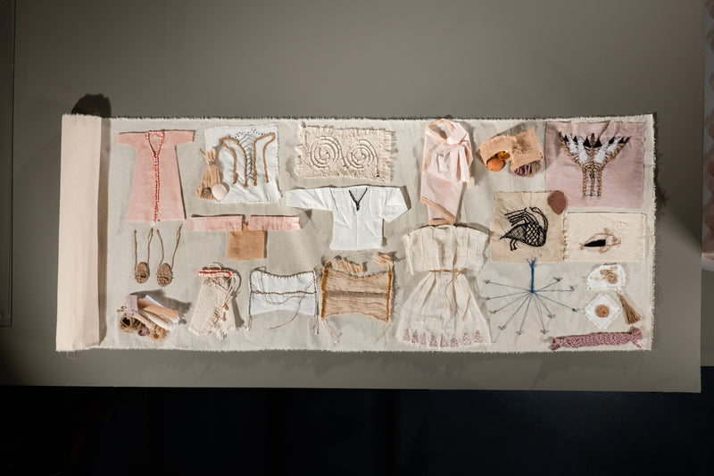 Collection of small clothing items and accessories displayed on a textured surface.